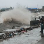 Anak bermain di sekitar jalan yang rusak akibat diterjang gelombang di Labuan, Pandeglang, Banten, Sabtu (27/11/2021).